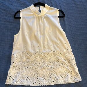 White sleeveless Theory top with embroidered patterns and eyelets